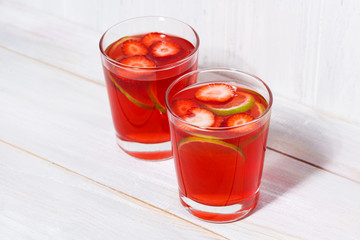 two glasses of strawberry-citrus lemonade on a white background