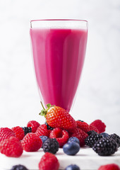 Milkshake glass with fresh summer berries smoothie