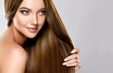 Beautiful brunette girl with long straight smooth hair . A woman with healthy straight hairstyle 
