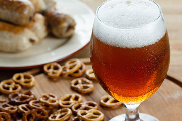 Glass of cold beer. Traditional pretzels german Oktoberfest snacks, sausage.