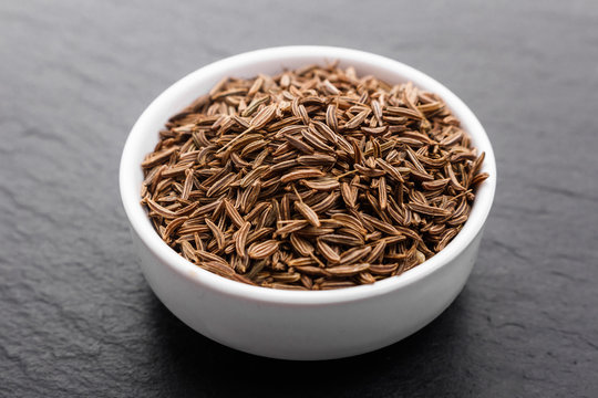 Seeds of cumin on a dark stone background
