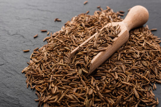 Seeds of cumin on a dark stone background