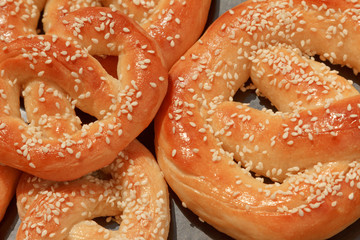 Freshly baked homemade soft pretzel with salt on rustic wooden table.