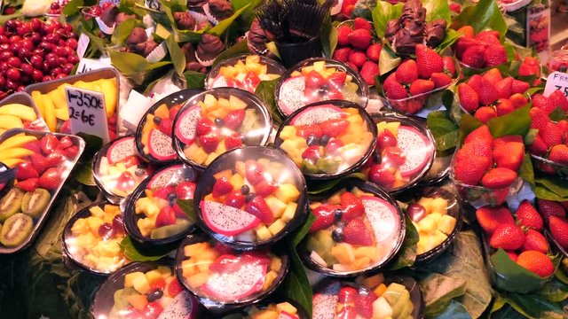 La Boqueria market - The famous fruit stand with a stunning display of products. La Boqueria is a large public market and one of the city's foremost tourist landmarks