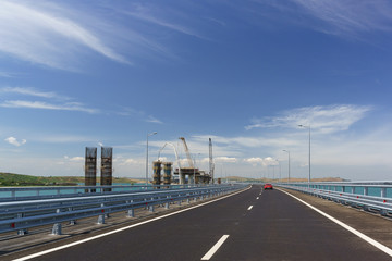 Fototapeta na wymiar Crimean bridge across the Kerch Strait. On the left is the construction of the railway bridge