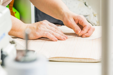 worker of sewing production uses scissors for cutting of fabric. Sewing production line