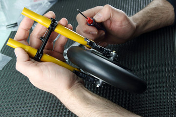 manos montando una maqueta de una moto