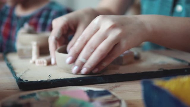 creating a plate of clay. a girl with beautiful hands sculpts an odd job at a pottery lesson