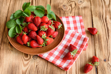 Tasty strawberry on a wooden table. It can be used as a background