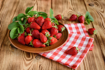 Tasty strawberry on a wooden table. It can be used as a background