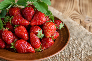 Tasty strawberry on a wooden table. It can be used as a background