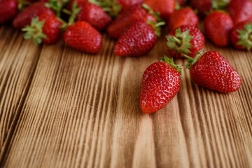 Tasty strawberry on a wooden table. It can be used as a background