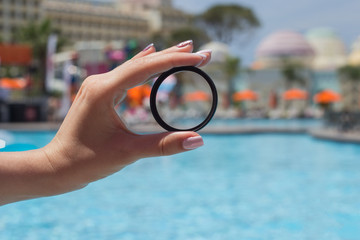 photo filter in the hand of a girl near the pool close-up