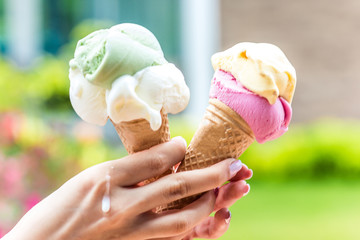 Two horns with ice cream in hot weather in a girl's hand