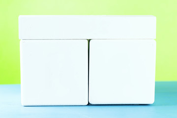 woden cube calendar on blue wooden surface with copy space