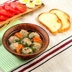 Tasty homemade soup with meatballs and vegetables on paper napkin. Square.