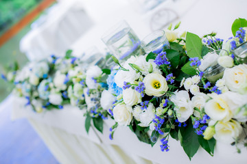 flowers on the wedding table table decoration flowers design floristics blue and white tablecloth glasses