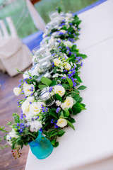 flowers on the wedding table table decoration flowers design floristics blue and white tablecloth glasses