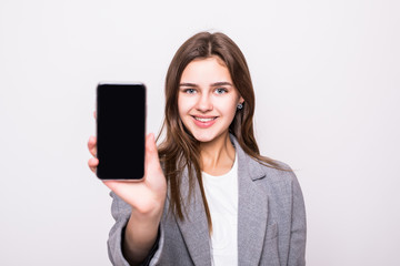 Fototapeta premium Portrait of a happy casual woman showing blank smartphone screen isolated on a white background