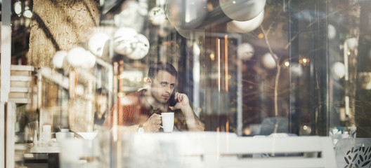 Fototapeta na wymiar Young attractive man drinking coffee at lunch time