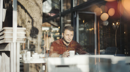 Fototapeta na wymiar Young attractive man drinking coffee at lunch time