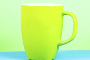 empty coffee cup on green background with copy space 