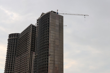 Fototapeta na wymiar Building crane and house under construction