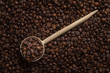 Wooden spoon with roasted coffee beans