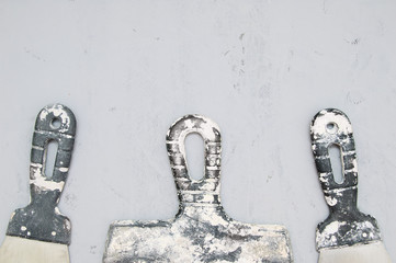Handles of dirty building putty knives on a concrete background. Close-up