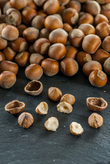 close up photo of a pile of raw hazelnuts on a slate