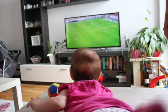 baby watching a soccer on TV