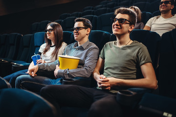 People with popcorn watching movie in cinema