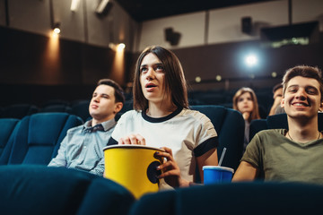 Surprised woman watching film in cinema