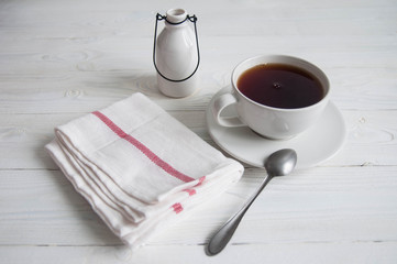 White cup of black tea or coffee on vintage wooden table