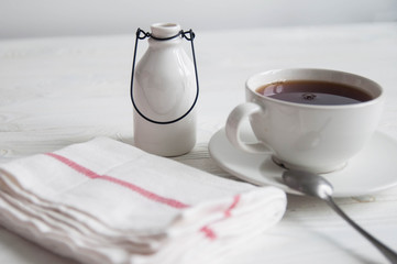 White cup of black tea or coffee on vintage wooden table