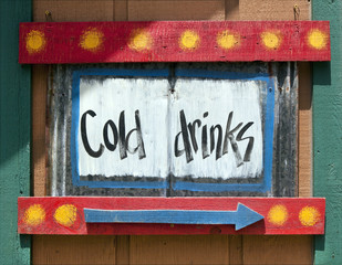 Colorful handmade COLD DRINKS wood sign with blue arrow.