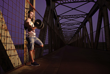 Obraz na płótnie Canvas Sportsman exercising outside on a bridge.