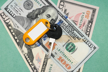 Studio image of keys and dollars on a green background