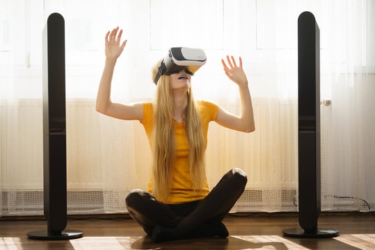 Girl wearing virtual reality goggles at home