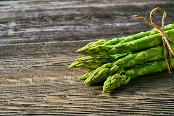 Fresh green shoots of asparagus on a gray wooden background