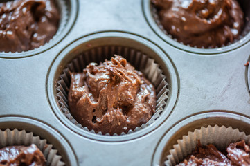 Close up. Raw dough for cupcake in baking tray. Process of cupcakes preparation. Homemade chocolate Cupcakes. Soft focus.