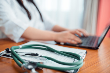 Stethoscope on wooden table, family doctor concept