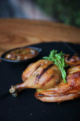 Grilled chicken on black dish wood background