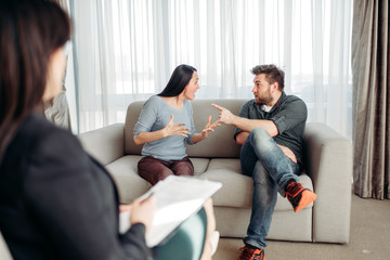 Obraz premium Couple sitting on sofa, psychologist reception