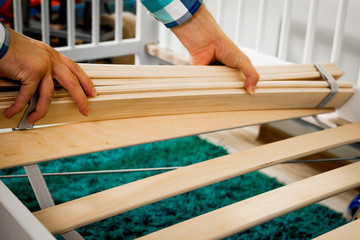 Construction of bed for children. The man puts the bed frame. Role of the father in child's life. Father folds bed for a newborn child, growing up children, Concept of parenthood.