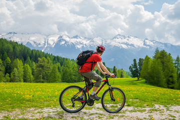 Fototapeta premium Slow life, MTB cyclist admires alpine mountain landscape