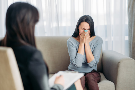 Female patient sitting on sofa at psychotherapist