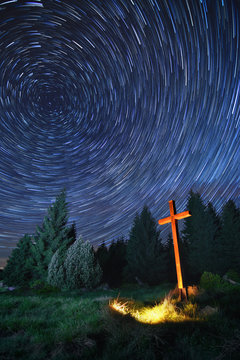 rotating star trails with illuminated wooden Christian cross