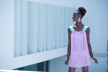 beautiful and attractive black model woman wearing a lilac and blue fringed dress with a fashion...