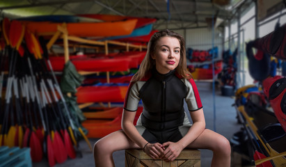 Obraz premium Female sportman in wetsuit, boats on background
